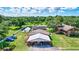 Exterior view featuring a rustic home and spacious garage and carport with ample parking on a verdant lot at 6501 62Nd N St, Pinellas Park, FL 33781