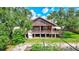A rustic home exterior, surrounded by mature trees and featuring a charming covered porch at 6501 62Nd N St, Pinellas Park, FL 33781