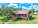 Rustic exterior of the home featuring wooden siding, a spacious porch, and a well-maintained lawn at 6501 62Nd N St, Pinellas Park, FL 33781