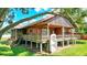 Rustic wood home featuring a wooden deck with weathered railing and stone foundation, blending with the natural landscape at 6501 62Nd N St, Pinellas Park, FL 33781