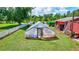 Well-kept greenhouse surrounded by a lush green lawn and mature trees, perfect for cultivating plants at 6501 62Nd N St, Pinellas Park, FL 33781