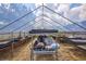 View of greenhouse interior with metal frame, shelving, and clear roofing with cloudy sky at 6501 62Nd N St, Pinellas Park, FL 33781