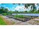 Large vegetable garden with wooden planters and rows of metal supports for growing various vegetables at 6501 62Nd N St, Pinellas Park, FL 33781