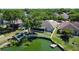 Aerial view of the backyard showcasing the screened porch and lake with a private dock at 7123 Colonial Lake Dr, Riverview, FL 33578