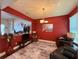 Dining room with elegant lighting, red accent wall, and seamless transition to the living area at 7123 Colonial Lake Dr, Riverview, FL 33578