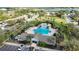Aerial view of a pool and clubhouse surrounded by palm trees and green space at 7653 Stoney Hill Dr, Wesley Chapel, FL 33545