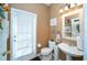 Neutral half-bathroom featuring a single sink, toilet, and large door with blind at 7653 Stoney Hill Dr, Wesley Chapel, FL 33545
