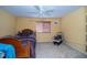 Bedroom with tan carpet and yellow walls featuring a window with horizontal blinds at 7653 Stoney Hill Dr, Wesley Chapel, FL 33545
