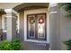 Covered front entryway features double doors with decorative glass inserts and welcome mat at 7653 Stoney Hill Dr, Wesley Chapel, FL 33545