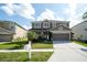 Two-story home features a well-manicured lawn, covered front porch, and attached two-car garage at 7653 Stoney Hill Dr, Wesley Chapel, FL 33545