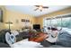 Bright living room with hardwood floors and a ceiling fan opens to the screened in lanai and pool at 7653 Stoney Hill Dr, Wesley Chapel, FL 33545