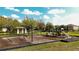Community playground with slides, swings, and covered seating area surrounded by grassy areas at 7653 Stoney Hill Dr, Wesley Chapel, FL 33545