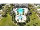 Aerial view of a large community pool surrounded by palm trees and manicured landscaping at 7653 Stoney Hill Dr, Wesley Chapel, FL 33545