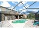 Screened-in pool area with brick pavers, outdoor seating, and lush backyard in a serene setting at 7653 Stoney Hill Dr, Wesley Chapel, FL 33545