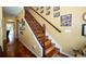 Hallway featuring a stained wood staircase with decorative accents and many framed photos at 7653 Stoney Hill Dr, Wesley Chapel, FL 33545