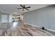 Open-concept living room with wood-look flooring and a ceiling fan, connected to a modern kitchen at 880 S Village N Dr # 201, St Petersburg, FL 33716