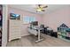 Bedroom with light wood flooring, large window, white desk, and ceiling fan at 90 S Highland Ave # 1317, Tarpon Springs, FL 34689