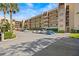 Multi-story condo building with palm trees and ample parking under a bright blue sky at 90 S Highland Ave # 1317, Tarpon Springs, FL 34689