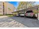 Carport area with multiple cars parked underneath the structure, next to the building at 90 S Highland Ave # 1317, Tarpon Springs, FL 34689