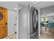 Inviting entryway featuring a vibrant yellow door, neutral walls, and a modern, stainless steel refrigerator at 90 S Highland Ave # 1317, Tarpon Springs, FL 34689