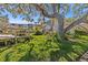 Lush, landscaped grounds with mature tree and view of building at 90 S Highland Ave # 1317, Tarpon Springs, FL 34689