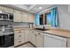 Updated kitchen featuring neutral cabinetry, modern appliances, a black sink, and window for natural light at 90 S Highland Ave # 1317, Tarpon Springs, FL 34689