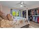 Bright bedroom featuring a walk-in closet, ceiling fan and sliding glass door leading to a private patio at 90 S Highland Ave # 1317, Tarpon Springs, FL 34689