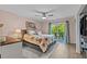Serene bedroom with floral bedding, a ceiling fan, and a sliding glass door leading to a private balcony at 90 S Highland Ave # 1317, Tarpon Springs, FL 34689