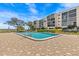 Community pool with lounge chairs and a view of the building at 90 S Highland Ave # 1317, Tarpon Springs, FL 34689