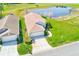 Aerial shot of a home with a two-car garage, adjacent to a pond, with green surroundings at 9426 Green Needle Dr, New Port Richey, FL 34655