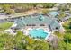 Beautiful aerial view of the clubhouse with its sparkling pool and lush green landscaping at 9426 Green Needle Dr, New Port Richey, FL 34655