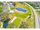 Aerial view showcasing a golf course community with ponds and lush greenery, offering a scenic and active lifestyle at 9426 Green Needle Dr, New Port Richey, FL 34655