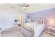 Airy bedroom features a white bed frame, light purple walls, and a peek into the en-suite bathroom at 9426 Green Needle Dr, New Port Richey, FL 34655