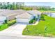 Well-maintained home with lush landscaping, a two-car garage, and a view of the nearby pond at 9426 Green Needle Dr, New Port Richey, FL 34655