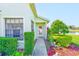 Inviting entryway features a decorative glass door, colorful flowers, and established shrubbery at 9426 Green Needle Dr, New Port Richey, FL 34655