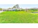 Expansive front lawn with mature landscaping and a tranquil pond view, creating an inviting curb appeal at 9426 Green Needle Dr, New Port Richey, FL 34655