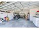 Spacious garage with golf cart, washer, dryer, and ample storage space with overhead door and bright lighting at 9426 Green Needle Dr, New Port Richey, FL 34655