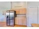 Kitchen area showcases stainless steel refrigerator, light wood cabinets, and a 'Friends and Wine' sign at 9426 Green Needle Dr, New Port Richey, FL 34655