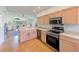Efficient kitchen with stainless steel appliances, wood cabinets, and natural light at 9426 Green Needle Dr, New Port Richey, FL 34655