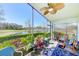 Relaxing screened lanai with ceiling fan, rocking chairs, and a beautiful view of the golf course and pond at 9426 Green Needle Dr, New Port Richey, FL 34655