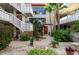 Inviting courtyard with lush plants, white stairs, and red accents at 1012 Pearce Dr # 105, Clearwater, FL 33764