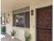 Apartment exterior with red front door, screened window, and potted plants at 1012 Pearce Dr # 105, Clearwater, FL 33764