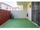 Private patio area with green flooring, surrounded by brick and a secure wrought iron gate at 1012 Pearce Dr # 105, Clearwater, FL 33764