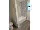 Bathroom with modern tiling around the tub and a window for natural light at 10216 N Pawnee Ave, Tampa, FL 33617
