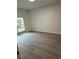This bedroom features wood-look floors and a bright window overlooking the yard at 10216 N Pawnee Ave, Tampa, FL 33617