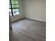 Bright bedroom with modern gray flooring and a large window for natural light at 10216 N Pawnee Ave, Tampa, FL 33617