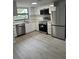 Well-lit kitchen featuring modern stainless steel appliances and bright white cabinets at 10216 N Pawnee Ave, Tampa, FL 33617