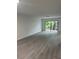 Bright living room with wood-look flooring and sliding glass doors to the outdoors at 10216 N Pawnee Ave, Tampa, FL 33617