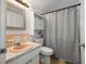 Quaint bathroom with retro peach sink, tiled backsplash, and shower with striped curtain at 10900 Oakdale Ave, Port Richey, FL 34668