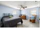 Comfortable bedroom features two windows, tile flooring, and a ceiling fan at 10900 Oakdale Ave, Port Richey, FL 34668